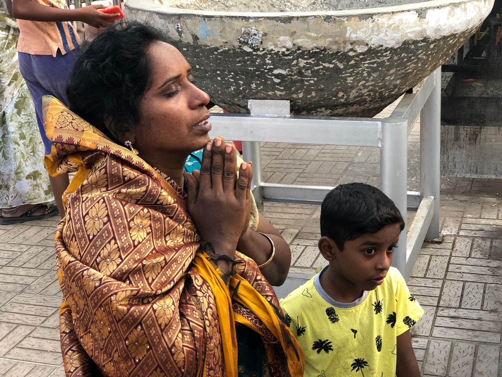 Women praying with child next to her India College of Ministry