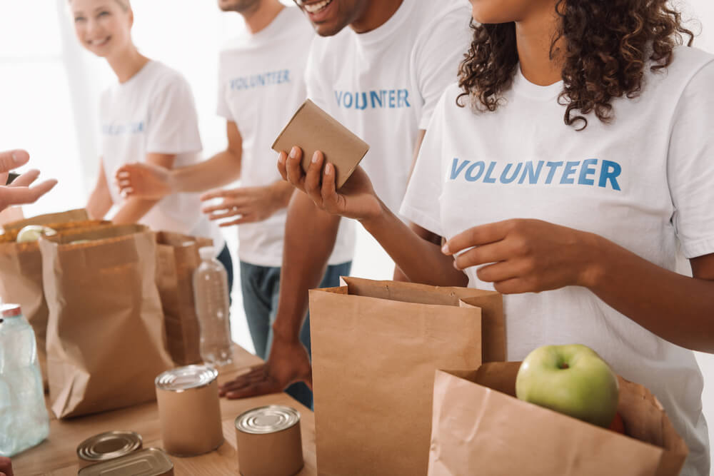 Christian volunteers serve canned goods and food