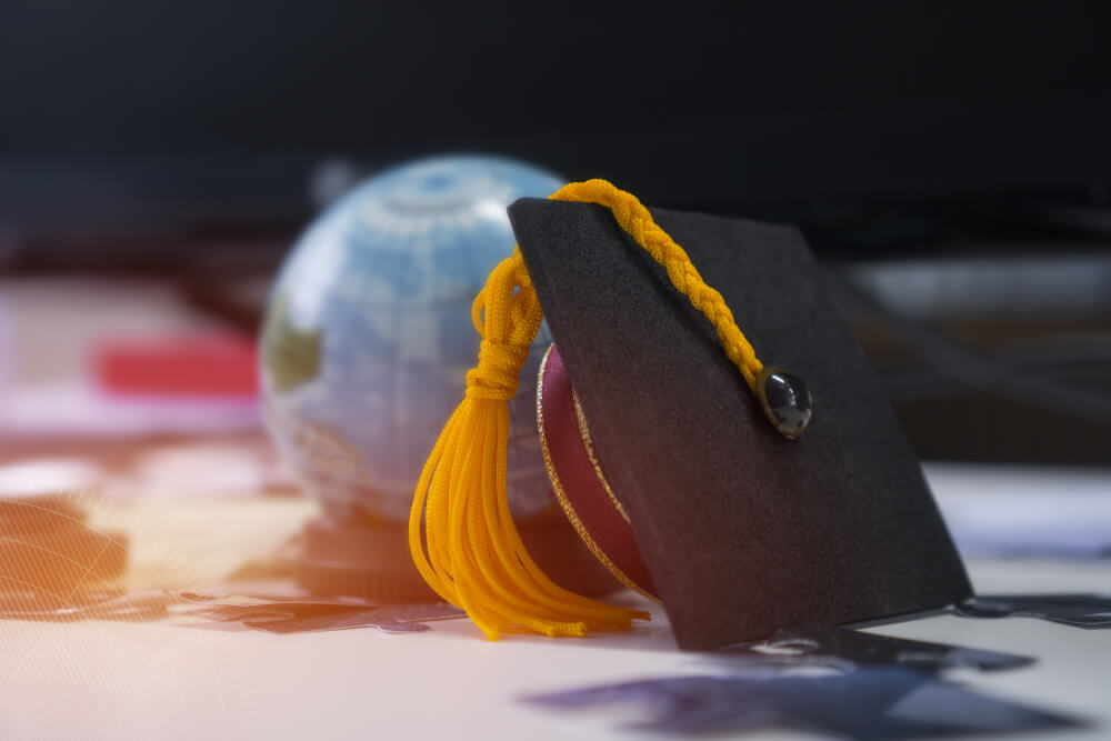 graduation cap next to a globe
