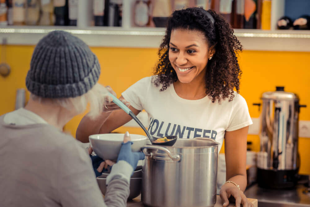 Volunteer smiling while serving food