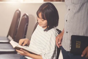 Student reading a Bible and smiling